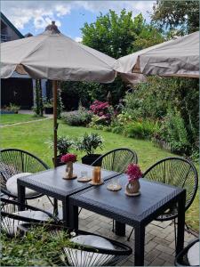 a blue table with two chairs and an umbrella at Schlosspartie stilvolle Ferienwohnung an der Nordsee in Sande