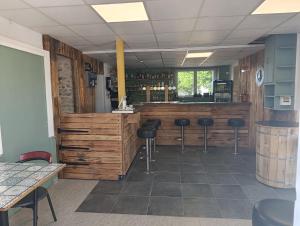a bar in a restaurant with stools in a room at La Halte in Torigni-sur-Vire