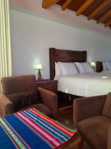 a bedroom with a bed and a couch and chairs at Casa de la Luna - ISLA DEL SOL in Comunidad Yumani