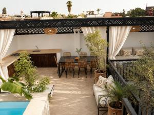 a patio with a table and chairs and a pool at Riad privé Maskat, piscine, petit-déjeuners, proche Jemaa el-Fna in Marrakesh