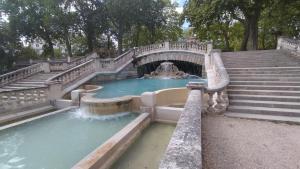 a water fountain with a bridge and stairs at l'oasis de paix in Dijon