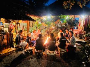 a group of people sitting around a fire at night at Serengeti Villa in Arusha