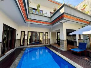 a swimming pool in a villa with a house at Ramantika Sunset Bay in Nusa Dua