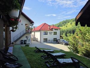 a view of a house with chairs and a car at Pensiunea Daniela in Moisei