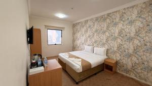 a small bedroom with a bed and a wall with a wallpaper at براديس لاند نبراس الهدئ in Mecca