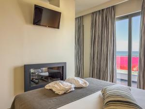a bedroom with a bed with a fireplace and a television at Olympus Thea Boutique Hotel in Platamonas +75 photos