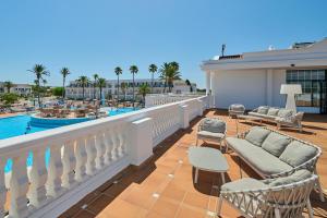 a balcony with a view of a swimming pool at Grupotel Mar de Menorca in Es Canutells