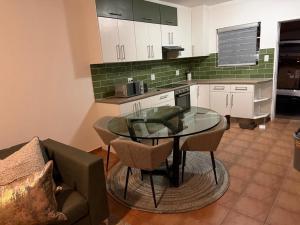 a kitchen with a glass table and a couch at Essie's Place in Windhoek