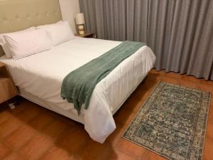 a bedroom with a bed with a green blanket on it at Essie's Place in Windhoek