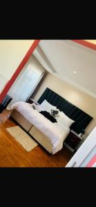 a large bed in a room with a window at Edladleni Guesthouse Quigney in East London