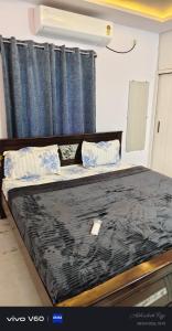 a bedroom with a large bed with blue curtains at Graps Ocean Stay in Chīrāla