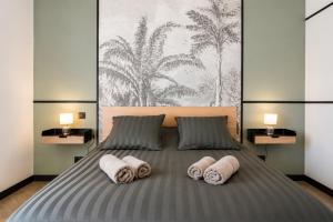 a bedroom with a bed with pillows and a painting at M a g i c & J u n g l e in Verdun-sur-Meuse
