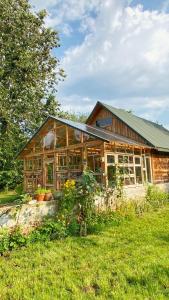 a wooden house with a garden in front of it at Magiczne Podlasie in Dubno