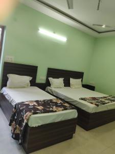 two beds sitting next to each other in a room at Friendly Guest House in Gorakhpur