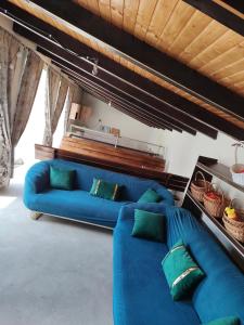 a living room with a blue couch and green pillows at Casa AIDA in Peşteana