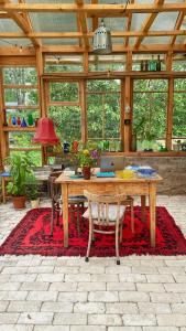 a dining room with a table and chairs on a red rug at Magiczne Podlasie in Dubno