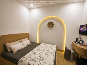 a bedroom with a bed and a sign on the wall at Khách Sạn MINTNACIE in Phan Rang–Tháp Chàm