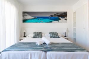 a bedroom with two beds and a painting on the wall at Hotel Capri Pollensa in Port de Pollensa