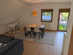 a living room with a table and chairs and a couch at Ferienwohnung am Hainer Berg in Heigenbrücken