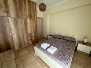 a bedroom with a large bed with wooden cabinets at Karfas Seascape in Chios