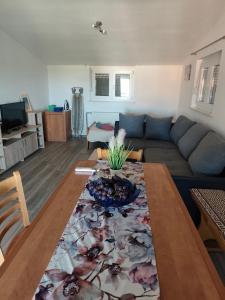 a living room with a couch and a table at Apartment Velebit with swimming pool - 10km from sea - 20km from Zadar in Benkovac
