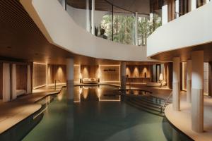 a swimming pool in a building with a large window at Hotel Col Alto in Corvara in Badia