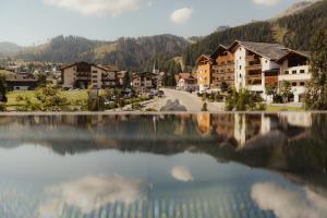 a view of a village from the water of a lake at Hotel Col Alto in Corvara in Badia