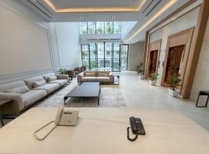 a lobby with a couch and a phone on a table at Barobi Apartment in Solpur