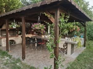 a wooden pavilion with a table and flowers at Lionz Village in Skala Fourkas
