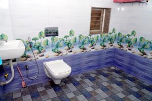 a bathroom with a toilet and a wall of plants at Sitara Homestay in Ratnagiri +7 photos