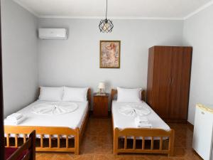 a room with two beds and a cabinet at Eiffel's Guest House in Pogradec