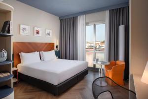 a hotel room with a bed and a window at UNA Hotels Mediterraneo Milano in Milan +28 photos