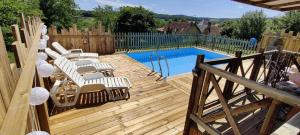 a wooden deck with chairs and a swimming pool at Gite De Baunac in Aubas