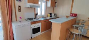 a small kitchen with a stove and a sink at Gite De Baunac in Aubas