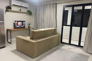 a living room with a couch and a tv at Compact Studios Close to Shopping Centers, Downtown, Arena, Airport in Manaus