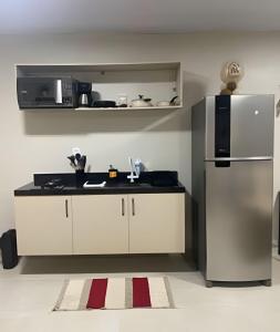 a kitchen with white cabinets and a stainless steel refrigerator at Compact Studios Close to Shopping Centers, Downtown, Arena, Airport in Manaus