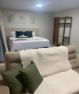 a living room with a couch and a bed at Compact Studios Close to Shopping Centers, Downtown, Arena, Airport in Manaus
