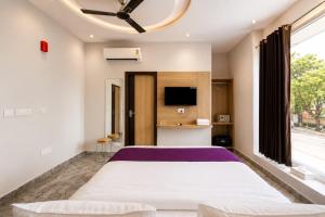 a bedroom with a large bed and a tv at Hotel Elev11 Near Ambala Chandigarh Highway, Zirakpur in Zirakpur
