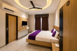 a bedroom with a bed and a ceiling fan at Hotel Elev11 Near Ambala Chandigarh Highway, Zirakpur in Zirakpur