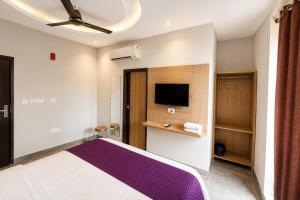a bedroom with a large bed and a flat screen tv at Hotel Elev11 Near Ambala Chandigarh Highway, Zirakpur in Zirakpur