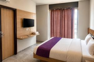 a hotel room with a bed and a television at Hotel Elev11 Near Ambala Chandigarh Highway, Zirakpur in Zirakpur