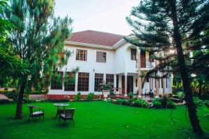 a house with a green yard with a table and chairs at Kilimanjaro pazuri summit villas 1 in Msaranga