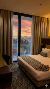 a hotel room with a bed and a large window at Hôtel Saint Eugène in Bab el Oued
