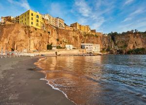 a view of a beach with buildings on a cliff at Sorrento Gem House in Meta