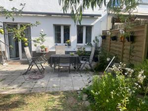 a patio with a table and chairs in front of a house at Gemütlicher Oase mit eigenen Bad in Zentrale, jedoch ruhige Lage in Mönchengladbach