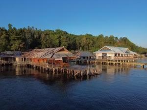 a group of houses on a dock in the water at Losmen Togean Wisata in Pulau Togian