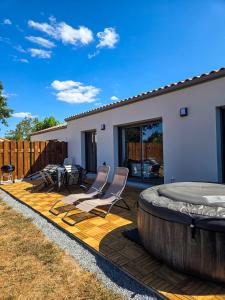 a wooden deck with chairs and a hot tub at Les embruns du retz in Chaumes en Retz