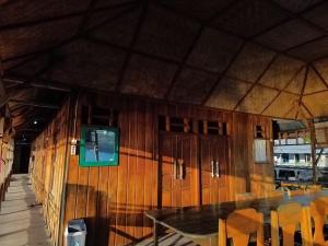 a room with a table and a tv on the wall at Losmen Togean Wisata in Pulau Togian
