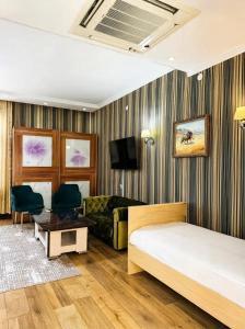 a hotel room with a bed and a couch at Seoul Hotel in Shymkent