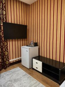 a room with a small refrigerator and a table at Seoul Hotel in Shymkent